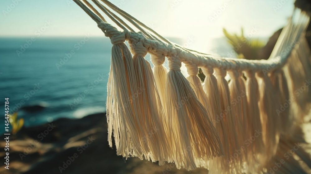 Close up of hammock tassels blowing near seaside breeze, blurred ocean horizon in backdrop