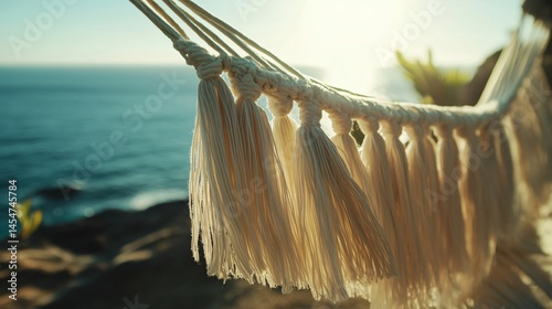 Obraz na płótnie Close up of hammock tassels blowing near seaside breeze, blurred ocean horizon in backdrop w salonie