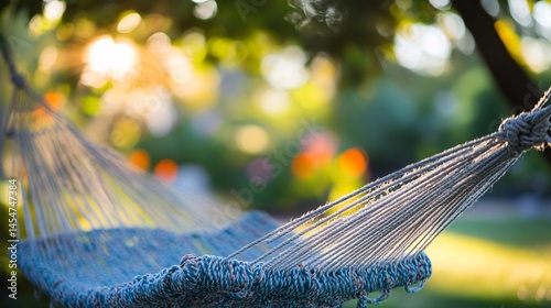 Obraz na płótnie Hammock strings tangled artistically, soft bokeh in background showing garden trees and flowers w salonie