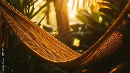 Obraz na płótnie Tight shot of hammock material with tropical leaves in the background, warm golden tones w salonie