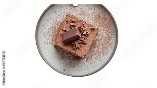 Top view of a square chocolate cake with a chocolate piece on a speckled plate isolated