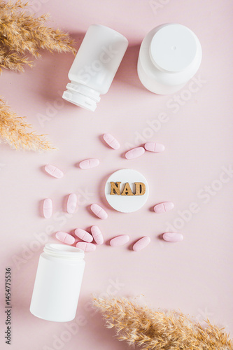 Obraz na płótnie NAD+ molecule in pills for anti-aging and biohacking on pink top and vertical view w salonie