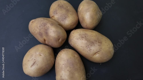 Fresh potato falls into the potato pile , cinematic slow motion