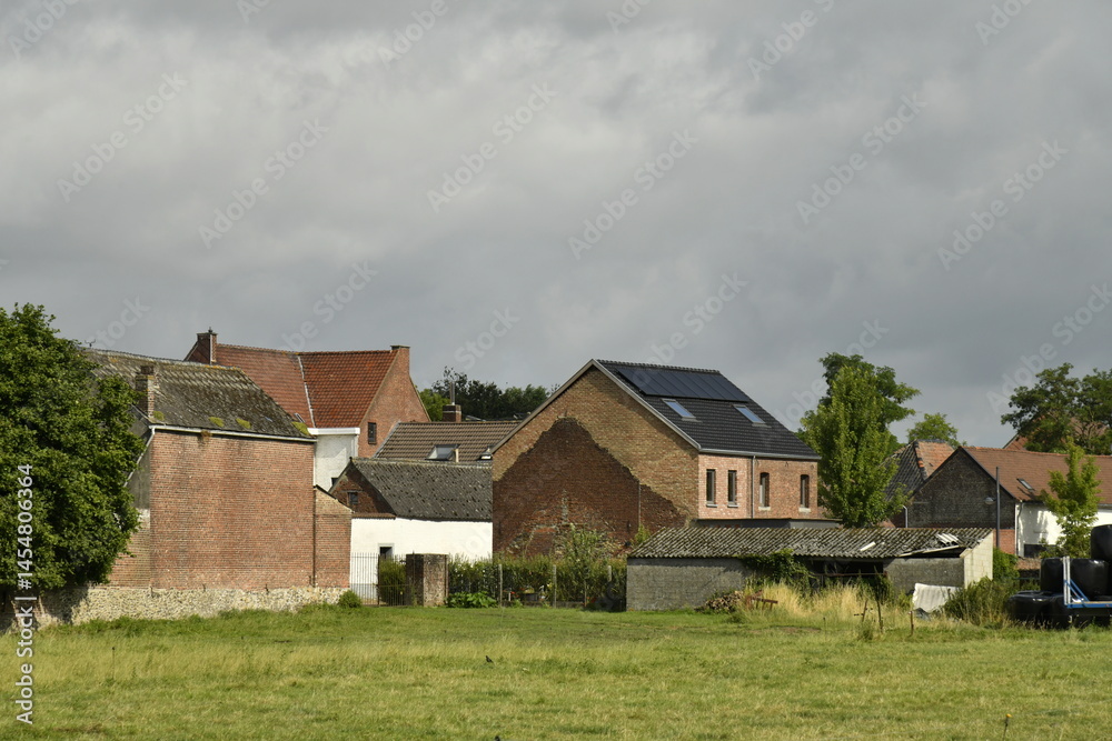 Obraz premium Ciel gris sur les toits des maisons et fermes à Hellebecq (Silly)
