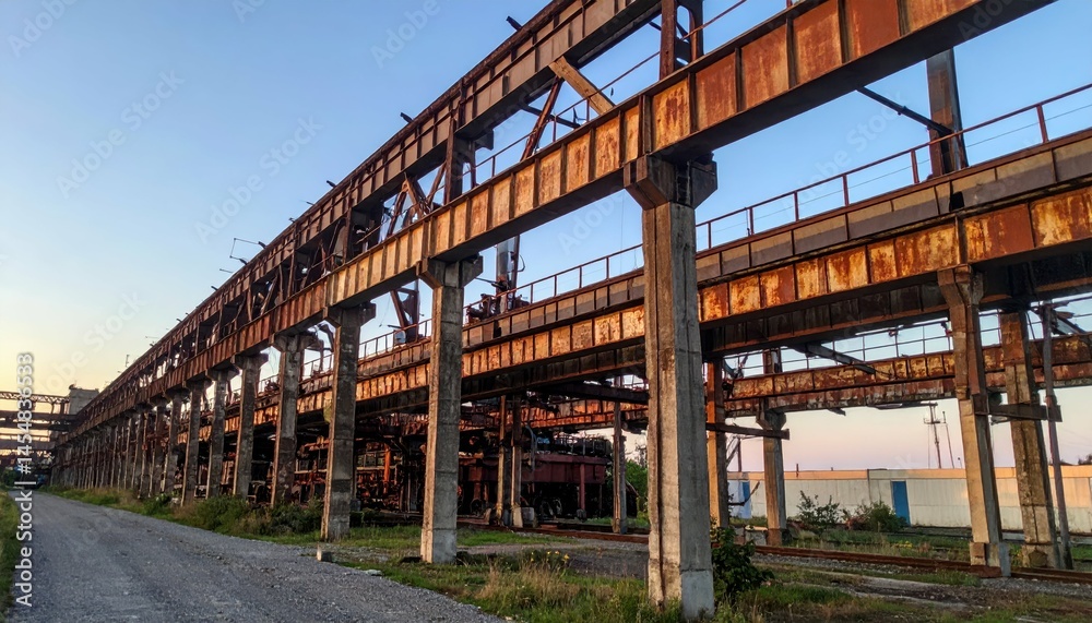 Abandoned industrial site with rusting beams and overgrown pathway Abandoned industrial site with rusting beams and overgrown pathway