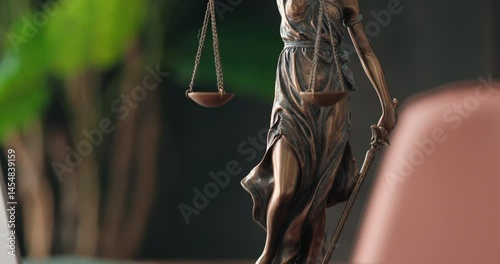 Lawyer's office. Statue of justice with scales and a laptop in a modern office cubicle. Concept of legal law, counseling and concept of justice.