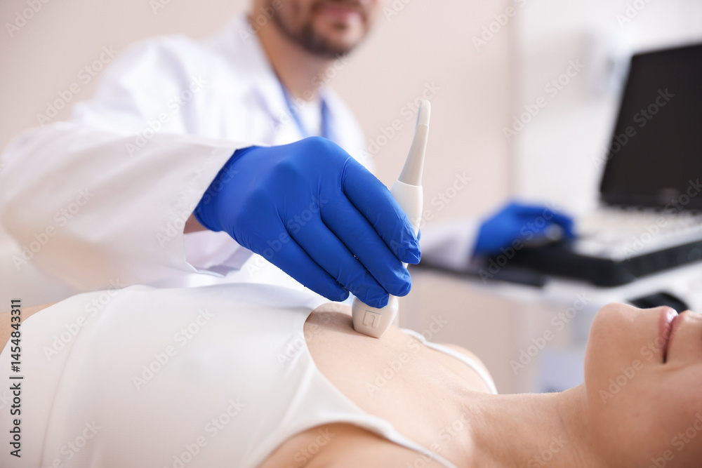 Fototapeta premium Sonographer conducting ultrasound examination of woman's heart in clinic, closeup