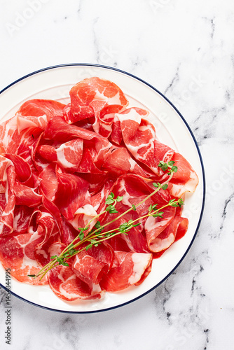 Obraz na plátně plate with sliced cured meat, pork neck, prosciutto coppa, Italian delicacy,