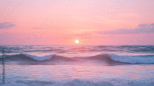 A soft pink and purple sunset over an ocean horizon with gentle waves.