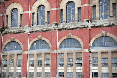 Photography Exterior of an old red brick building with large windows
