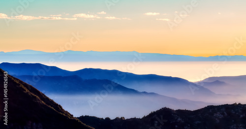Φωτογραφία A misty Ventana Wilderness mountain silhouetted landscape at dawn reveals a breathtaking sunrise painting the sky with soft sunlight