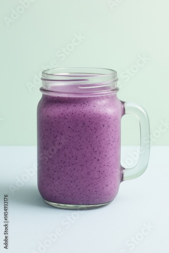 Smooth and Creamy Purple Smoothie in a Glass Jar on a Light Background