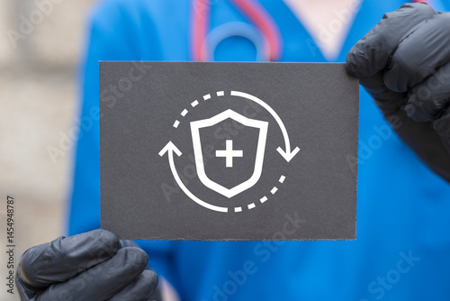 Obraz na płótnie Concept of health insurance, medical coverage planning, hospital payment support. Physician holding black paper card with shield icon symbolizing concept: HEALTH INSURANCE. w salonie