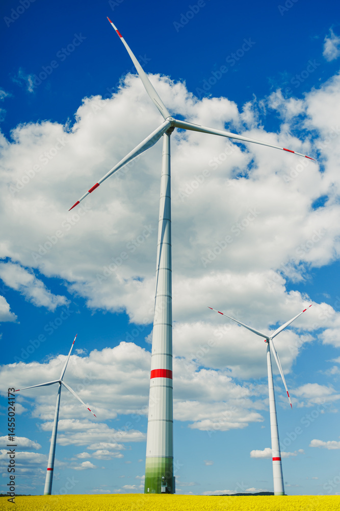 Wind turbine on sky background and grass with farmland for eco friendly environment or alternative energy in rural area. Energy with farm for sustainable ecosystem