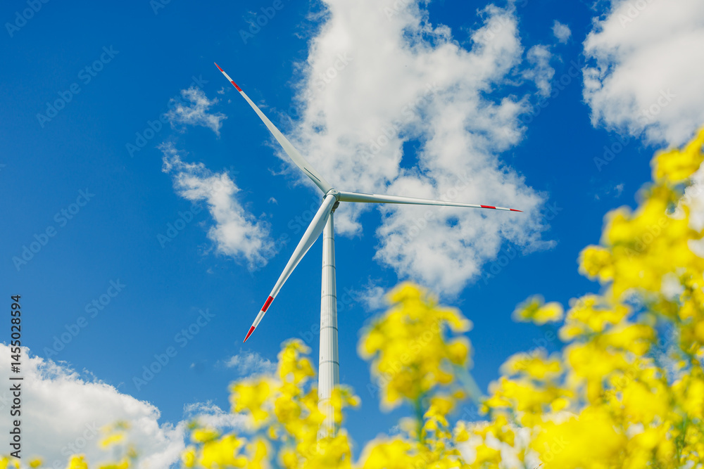 Ecological energy generation by windmills from the wind. Windmill field. Wind turbines generating energy against a clear blue sky. Wind turbines generating clean renewable energy in a rural field.