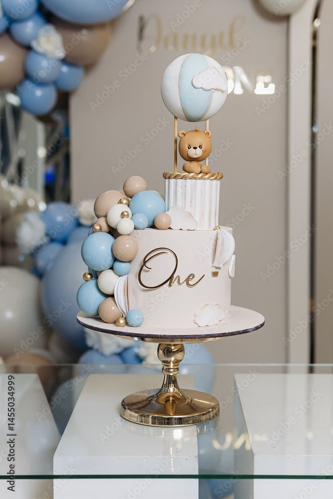 Sweet cake for a child's birthday decorated with a teddy bear. Two-story cake for a child. 1st birthday party for a child.