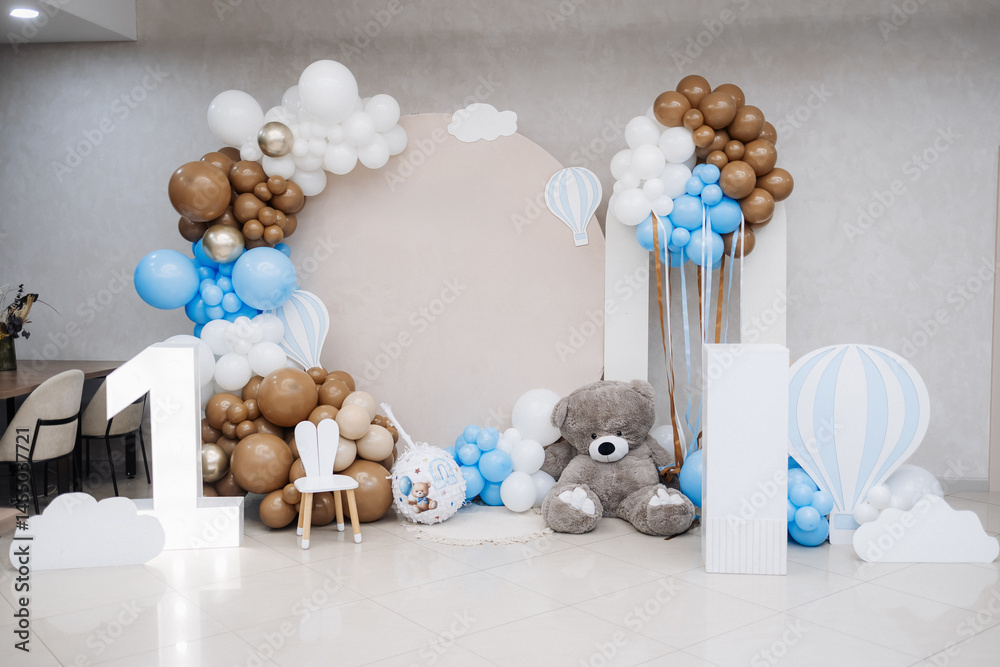Large photo zone for a children's birthday party with helium white balloons. Bright celebration of a children's birthday party with blue balloons.