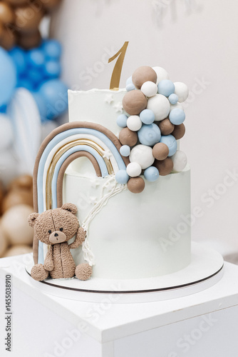 Obraz na płótnie Two-story sweet cake decorated with a teddy bear for a birthday celebration. Cake for a child's first birthday. CAKE for a one-year-old child. w salonie