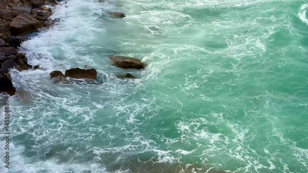 Fototapeta premium The Serene Ocean Waves Gently Crashing on the Rocky Shoreline Create a Peaceful Ambiance