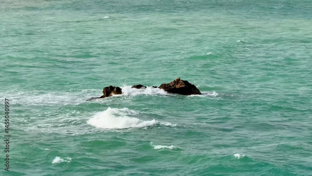 Fototapeta premium A Serene Coastal Rock Formation Surrounded by Crystal Clear Waters Offers a Picturesque View