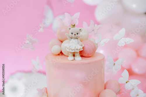 Obraz na płótnie Pink first birthday cake with teddy bear figurine. Soft pastel colors and festive decoration create a warm, festive atmosphere. Sweet cake for a one-year-old birthday girl w salonie