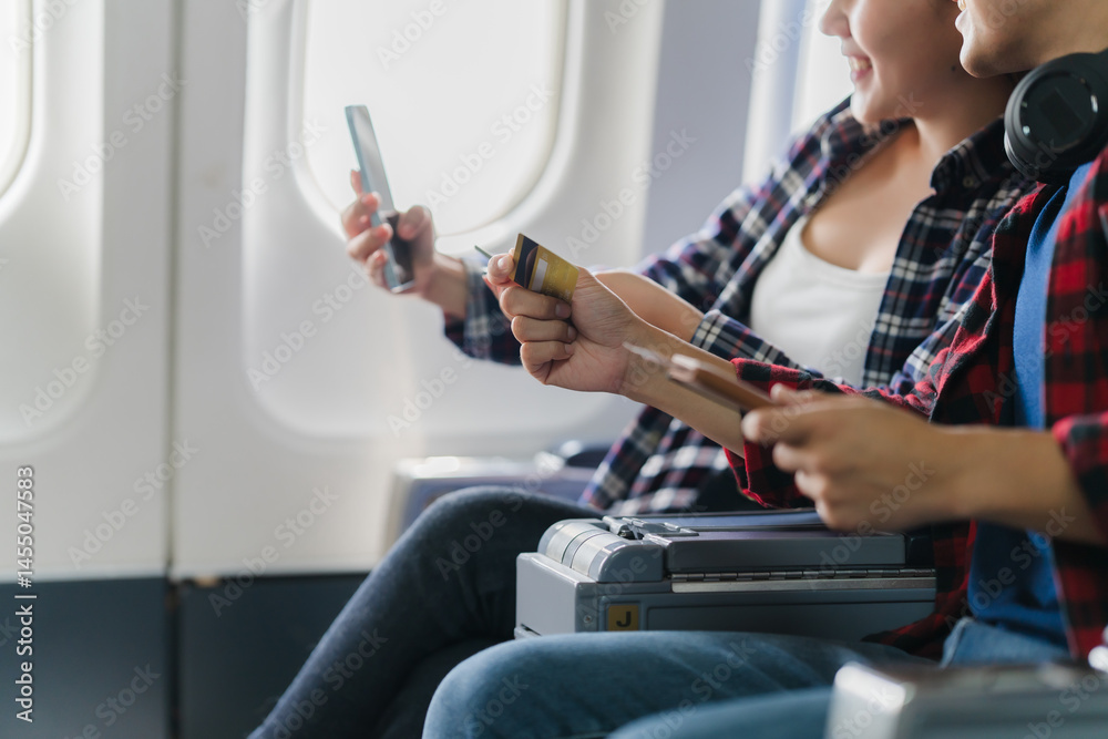 Couple Using Credit Card on Airplane