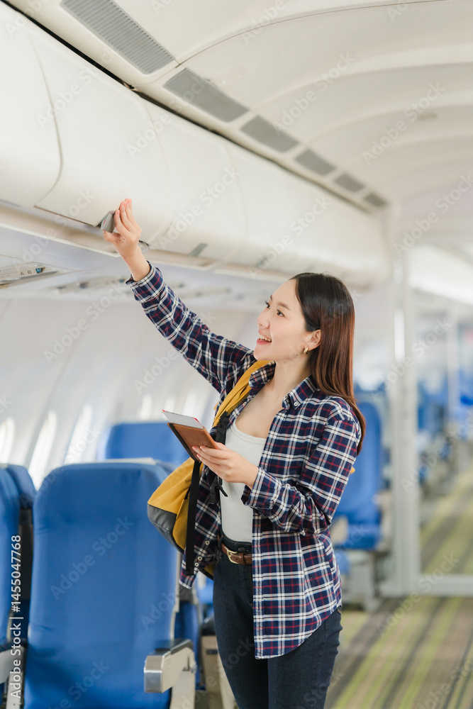 Woman Placing Luggage in Airplane Overhead Compartment