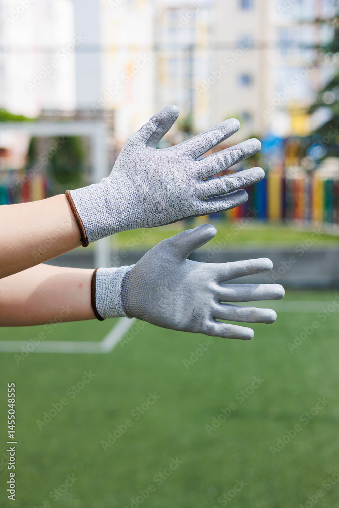 Rough gloves on men's hands for a construction worker. Construction gloves. Durable gloves for dirty work. Garden gloves. Rubberized construction gloves.