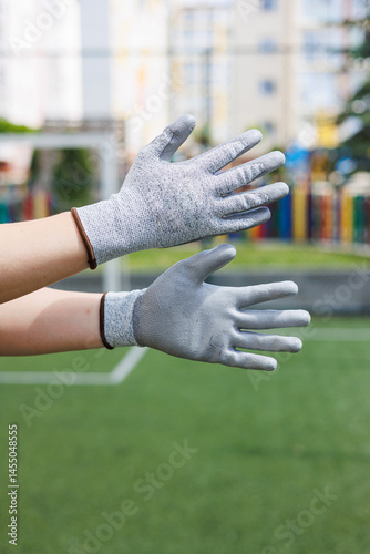 Obraz na płótnie Rough gloves on men's hands for a construction worker. Construction gloves. Durable gloves for dirty work. Garden gloves. Rubberized construction gloves. w salonie
