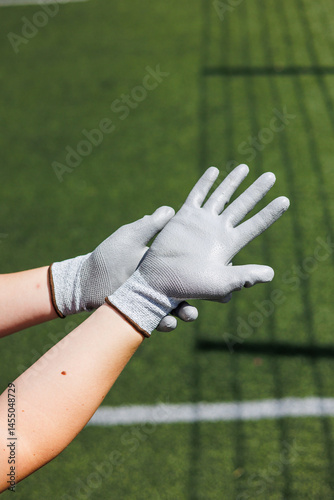 Obraz na płótnie Rough gloves on men's hands for a construction worker. Construction gloves. Durable gloves for dirty work. Garden gloves. Rubberized construction gloves. w salonie