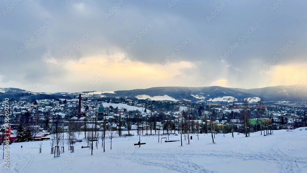 Obraz premium A winter landscape with a snowcovered town among mountains, perfect for outdoor activities