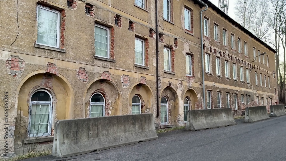 Obraz premium Abandoned Industrial Building in a Wealthy Urban Area with Diverse Architectural Features