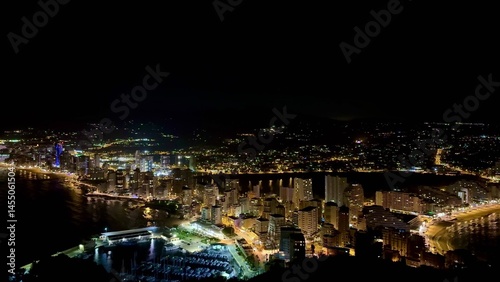 The stunning night view of a coastal city features beautifully illuminated, sparkling buildings