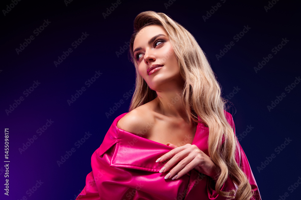 Obraz premium Elegant young woman in pink trench coat posing on vibrant violet background