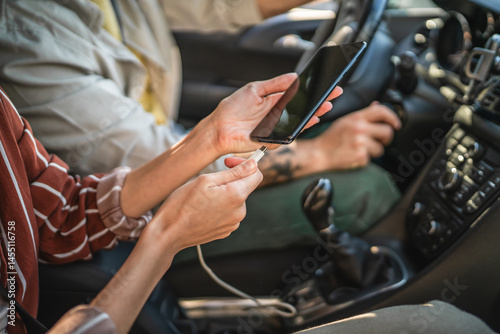 Quadro su tela close up on female hands puts the phone on charge into the car