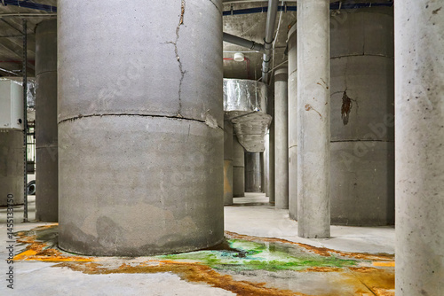 Leakage of Colored Water from Damaged Concrete Support Pillars Possibly Indicating an Issue with a Pool or Building Structure