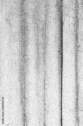 A close-up shot reveals a textured fabric densely patterned with tiny black dots against a stark white background.
