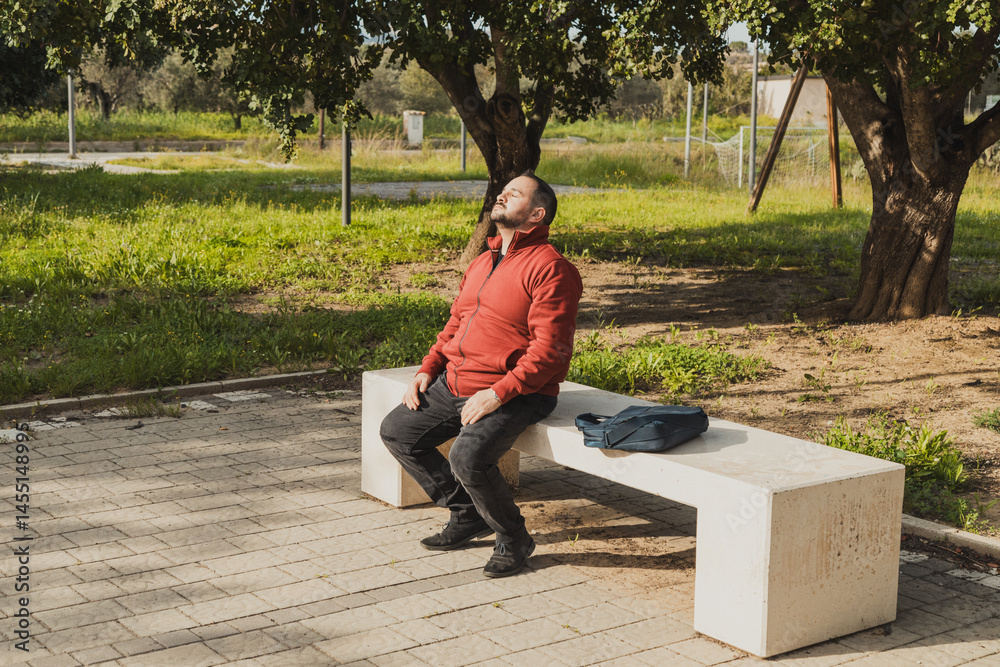 Man In The Park Of The City Relaxing On The Bench