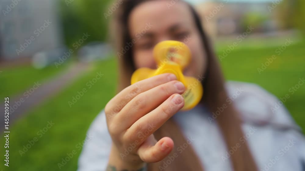 Happy woman spinning a fidget spinner in hand
