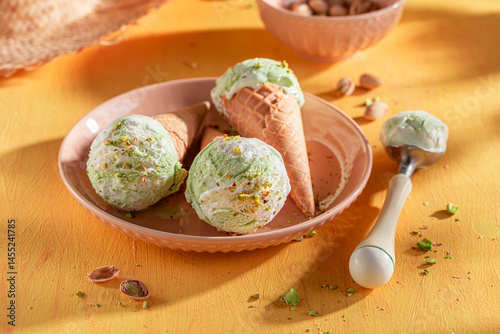 Obraz na płótnie Fresh and tasty pistachio ice cream in a waffle cone. w salonie