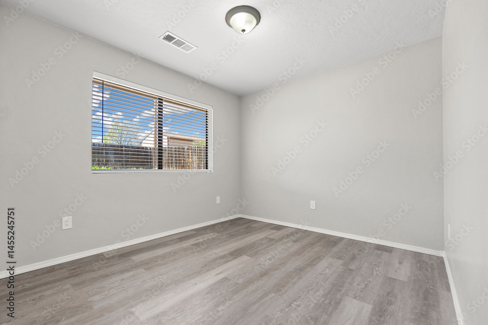 Fototapeta premium A vacant living room featuring hardwood floors and sliding doors