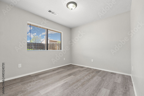 A vacant living room featuring hardwood floors and sliding doors