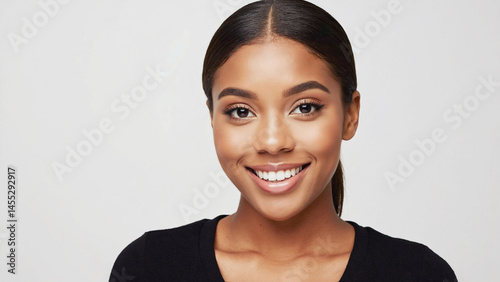Portrait of a smiling, confident young woman against a neutral background