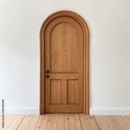 Arch top light wood door on a light cream wall.  Solid wood construction with three vertical panels