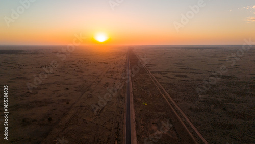 Sunset over the straight road in the desert