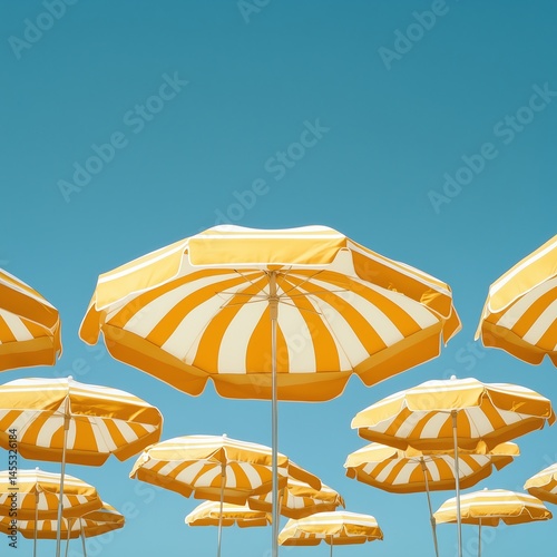 Pattern of yellow-white striped beach umbrellas against pure blue sky, geometric simplicity, summer minimalism with 30% negative space