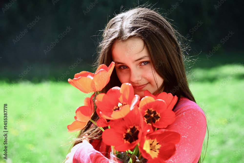Girl with tulips in spring park. Happy teen girl holding tulips flower bouquet. Child in blooming garden. Springtime joy in tulip field. Little girl outdoors. Portrait of dreamy child girl with tulips