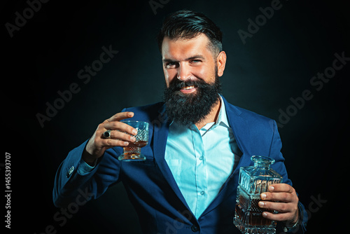 Obraz na płótnie Whiskey glass held by bearded man. Guy drinking whiskey alone at bar. Whiskey pour in classic vintage glass. Whiskey tasting with retro style. Expensive whisky. Cognac or whisky. Alcoholic beverage. w salonie