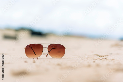 Sunglasses on summer beach vacation time to travel. Tropical summer beach with sea wave in sunshine day. Fashionable outdoor sunglasses accessory blue sea on seaside. Summer tropical sandy sunlight