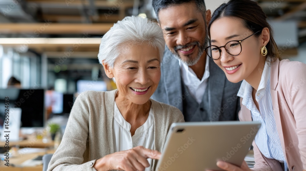 Fototapeta premium A woman, a man and a young woman are looking at a tablet